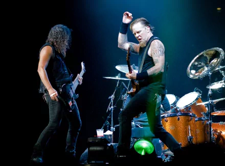HD desktop wallpaper featuring a live performance by the rock band Metallica, showcasing the intense energy of their music with guitarists playing passionately on stage.