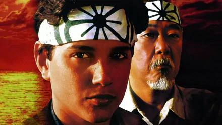 HD desktop wallpaper from the 1984 movie The Karate Kid, featuring the characters Daniel and Mr. Miyagi against a vibrant red and yellow background.