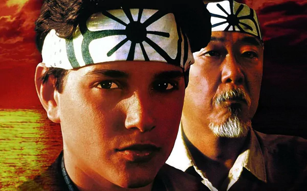 HD desktop wallpaper from the 1984 movie The Karate Kid, featuring the characters Daniel and Mr. Miyagi against a vibrant red and yellow background.