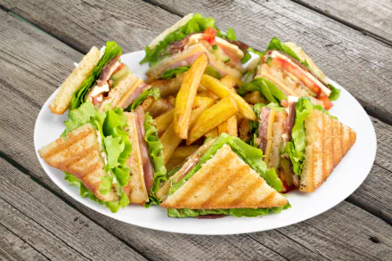 4K Ultra HD desktop wallpaper featuring a plate of sandwiches with lettuce and tomato, accompanied by golden French fries on a rustic wooden table.