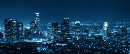 HD wallpaper of Los Angeles cityscape at night showcasing illuminated skyscrapers and buildings with the horizon in the background.