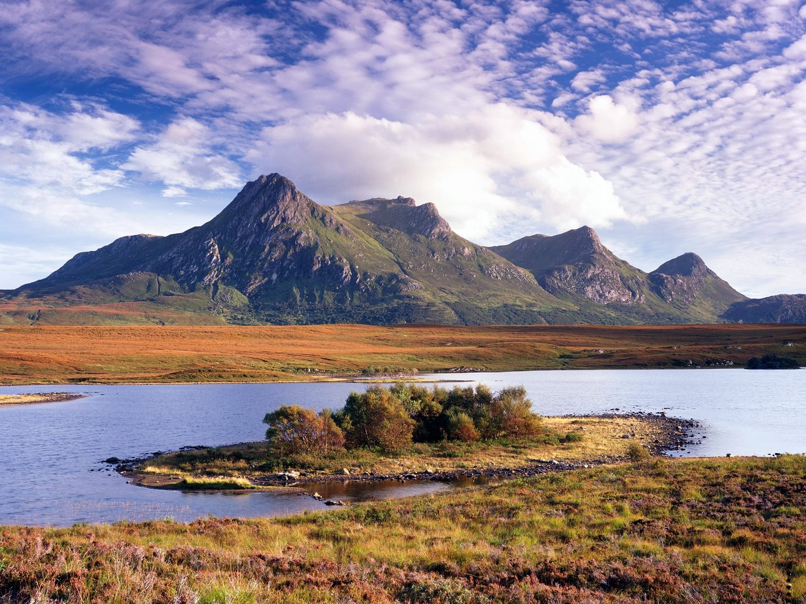 A serene river reflects majestic mountains under a vibrant sky, showcasing the beauty of nature in this stunning HD landscape wallpaper.