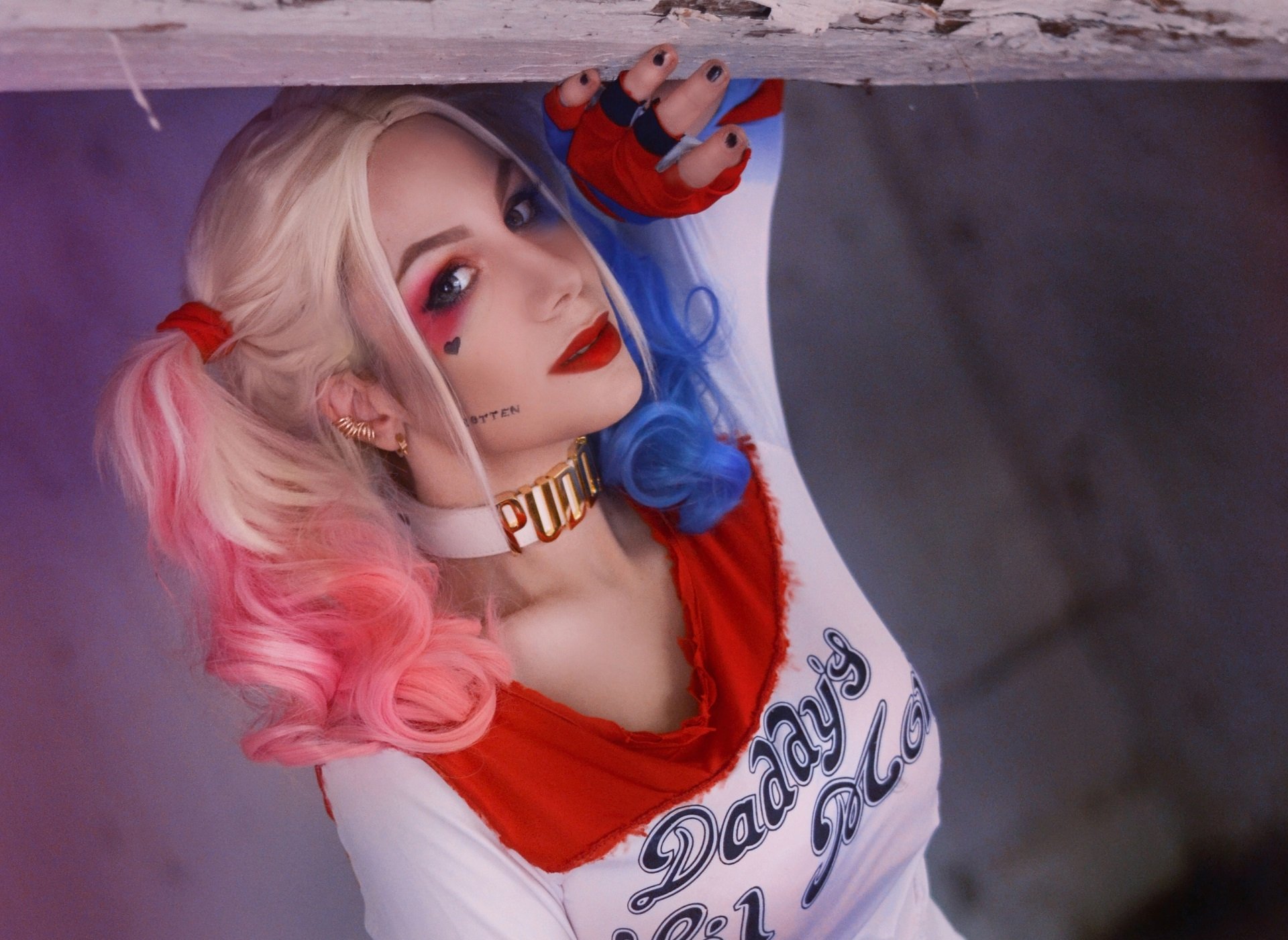 HD PC desktop wallpaper featuring a woman cosplaying Harley Quinn from DC Comics with pink and blue pigtails, red lips, and a Daddy's Lil Monster outfit.
