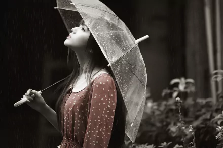 An HD desktop wallpaper featuring an Asian brunette woman in a dress holding an umbrella, gazing upwards pensively in the rain. The mood is serene and reflective.