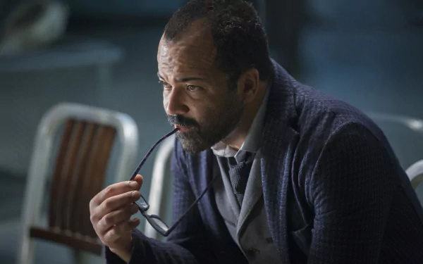 A contemplative Bernard Lowe, played by Jeffrey Wright, holds his glasses while deep in thought, captured in a scene from the TV show Westworld. A striking HD desktop wallpaper.