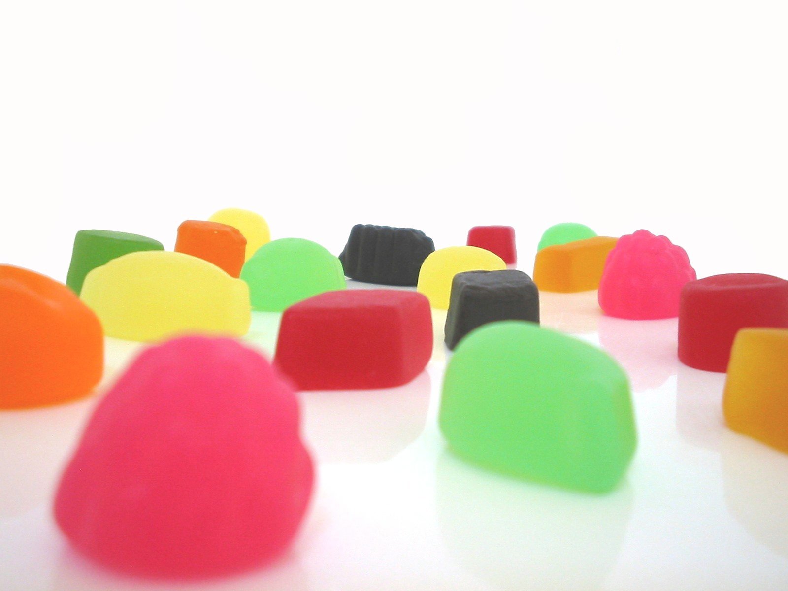 A vibrant assortment of colorful gummy candies scattered against a bright background, creating a cheerful and eye-catching HD PC desktop wallpaper.