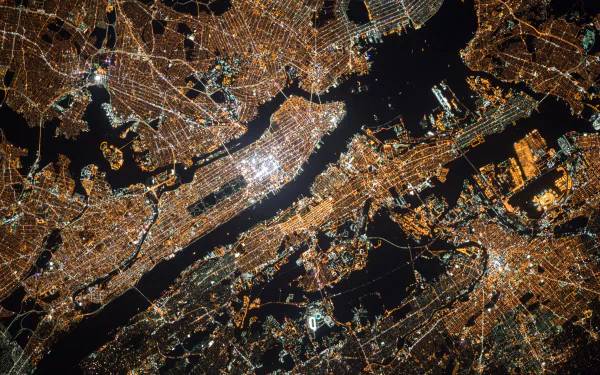 Aerial 4K Ultra HD night cityscape of New York and New Jersey, showcasing brightly lit urban streets and waterways in the USA.