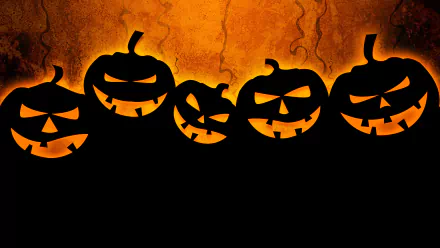 HD PC desktop wallpaper featuring a row of glowing jack-o'-lanterns with eerie expressions against an orange, cracked background for Halloween holiday.