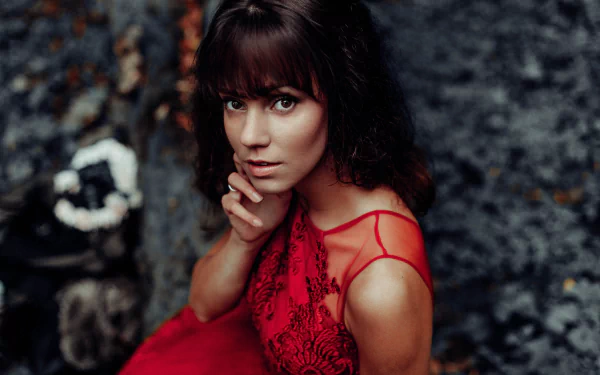 Brunette model with brown eyes in a red lace dress, gazing at the camera — 8K Ultra HD PC desktop wallpaper background.