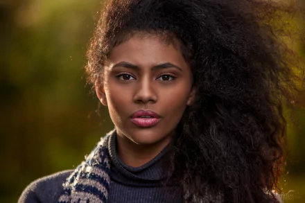 HD desktop wallpaper featuring a brunette model with brown eyes, showcasing a close-up of her face against a softly blurred natural background.