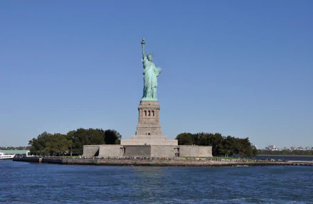 HD desktop wallpaper featuring the Statue of Liberty monument in Manhattan, New York, USA, showcasing the iconic man-made sculpture against a clear blue sky.