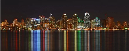 A stunning HD wallpaper showcasing the San Diego skyline at night, with vibrant lights reflecting on the water, highlighting the city's man-made beauty and urban charm.