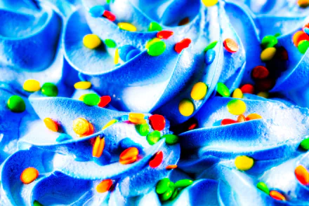 HD PC desktop wallpaper: close-up of bright blue ice cream swirls topped with colorful Smarties candy sprinkles — vibrant sweets food background.