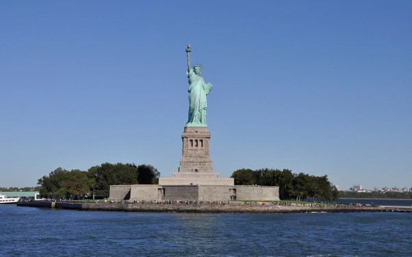 HD desktop wallpaper featuring the Statue of Liberty monument in Manhattan, New York, USA, showcasing the iconic man-made sculpture against a clear blue sky.