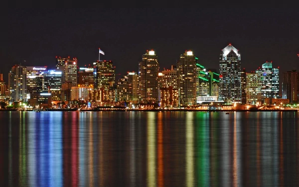 A stunning HD wallpaper showcasing the San Diego skyline at night, with vibrant lights reflecting on the water, highlighting the city's man-made beauty and urban charm.