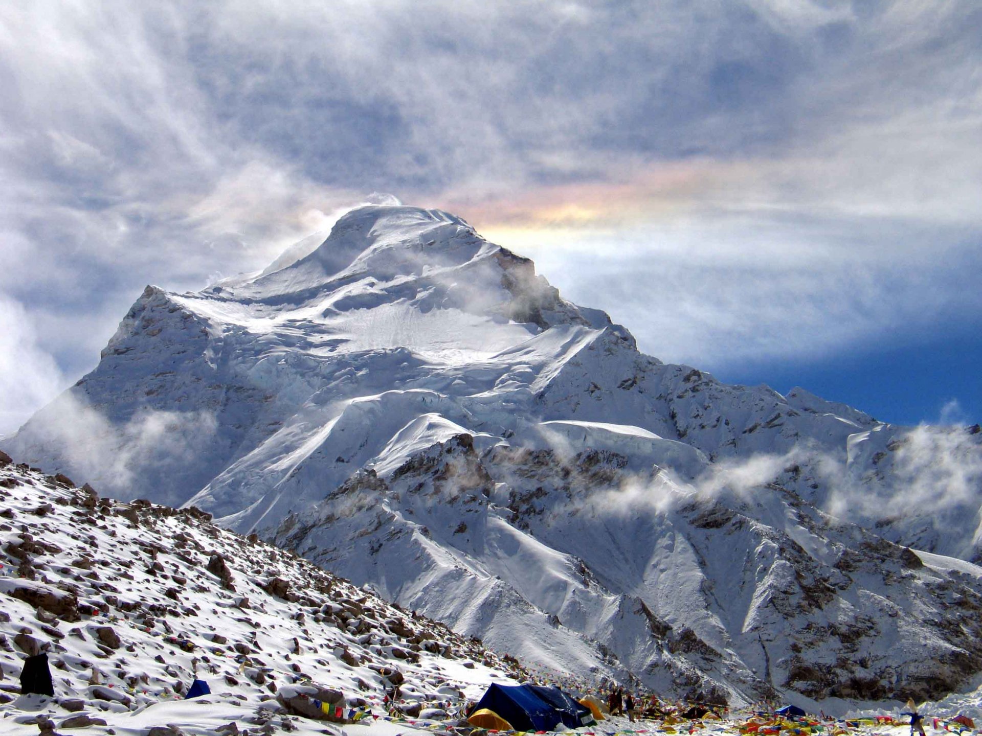 A breathtaking winter scene showcasing a majestic snow-capped mountain under a dramatic sky, capturing the serene beauty of nature in high-definition.