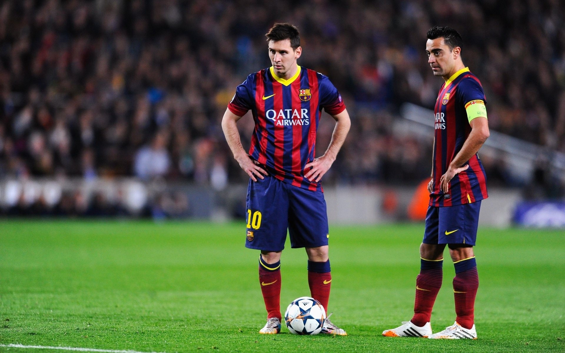 This HD wallpaper features Lionel Messi and Xavier Hernandez of FC Barcelona standing on the soccer field.