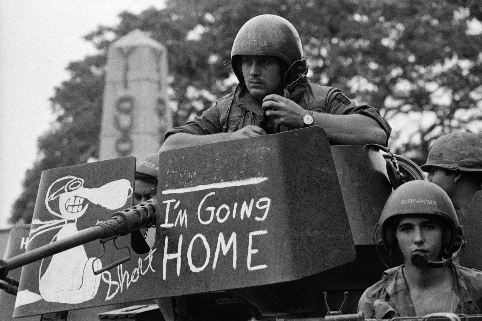 A black-and-white military scene featuring soldiers on a tank, with a humorous sign reading I'm Going HOME. This HD wallpaper captures the intensity and complexity of military life.