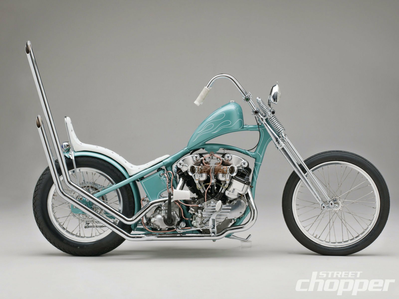 Teal vintage chopper motorcycle vehicle with long front fork and tall sissy bar, chrome engine and spoked wheels on a neutral gray backdrop — HD PC desktop wallpaper background