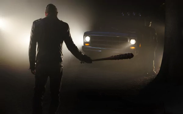HD desktop wallpaper featuring Negan from The Walking Dead standing in front of a truck, holding a bat. The scene is dark and atmospheric, evoking the tense mood of the TV show.