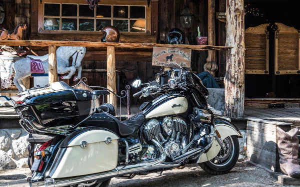 HD PC desktop wallpaper and background, vehicle: a cream-and-black Indian Roadmaster touring motorcycle parked before a rustic wooden storefront, chrome gleaming.