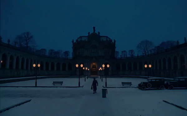 Night view of a courtyard at The Grand Budapest Hotel, featuring a historic building illuminated by warm street lamps, captured in an HD movie wallpaper.