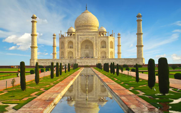 HD desktop wallpaper of the Taj Mahal in India, featuring its iconic dome and reflection in the central pool, surrounded by manicured gardens and blue sky.