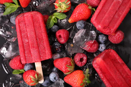Vibrant 8K Ultra HD wallpaper featuring blackberry, raspberry, blueberry, and strawberry popsicles with fresh berries and ice cubes on a dark background.