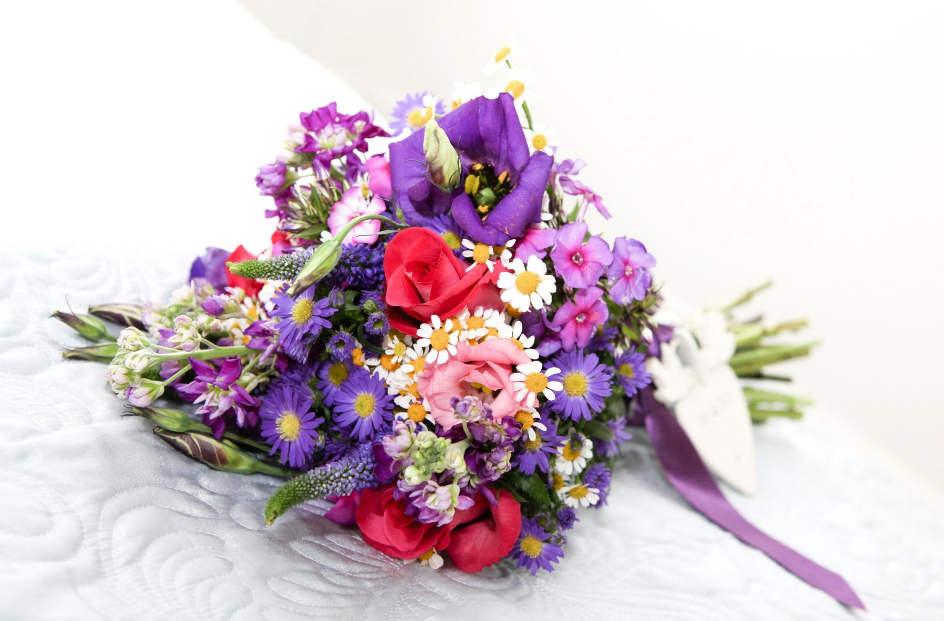 Vibrant man-made bouquet of purple chrysanthemums, pink eustoma and red roses on a white backdrop, HD PC desktop wallpaper