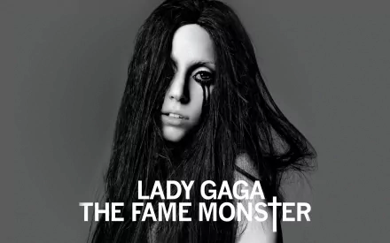Black and white HD desktop wallpaper of Lady Gaga with long hair and dark makeup, featuring the text Lady Gaga The Fame Monster.