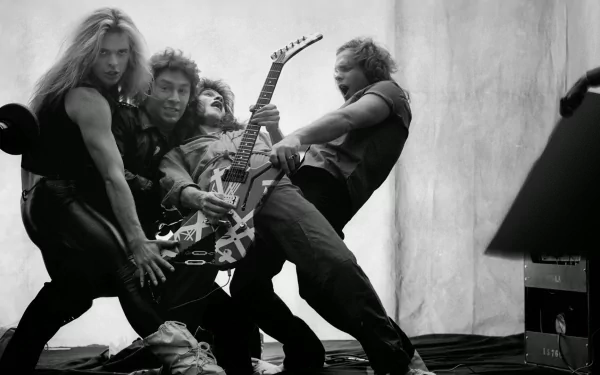 Black-and-white HD desktop wallpaper of a hard rock/heavy metal group in a wild pose, four musicians grappling a striped electric guitar, raw high-energy stage vibe.