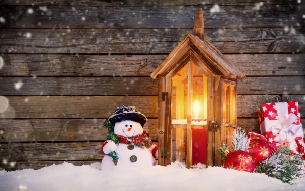 HD desktop wallpaper featuring a cheerful snowman next to a lit lantern, with Christmas decorations and gifts in the snow, set against a rustic wooden background.