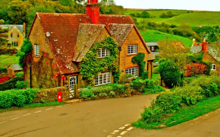 HD PC desktop wallpaper of a charming English village street featuring traditional man-made houses surrounded by lush greenery and rolling hills.