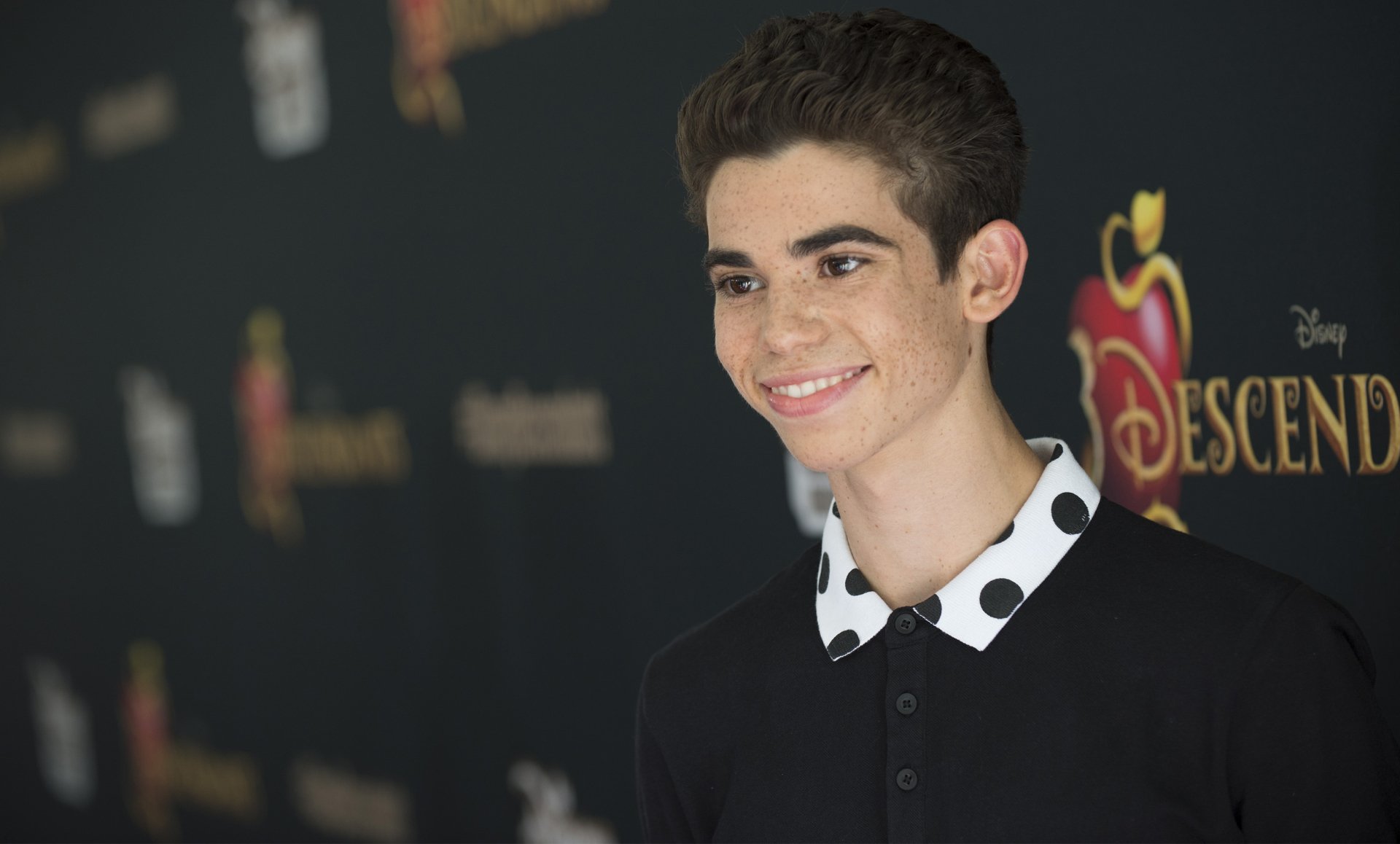 HD wallpaper of a smiling person at the 'Descendants' event, suitable as a desktop background.