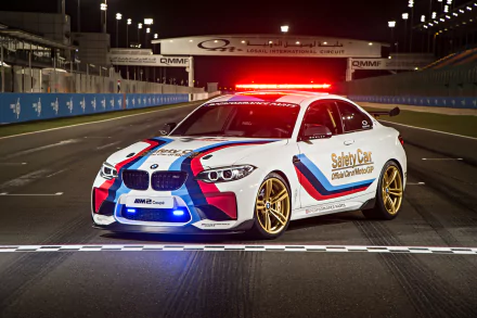 4K Ultra HD PC desktop wallpaper of a BMW M2 Coupe race car vehicle — white safety car with M‑stripes and flashing red lights on a night racetrack.