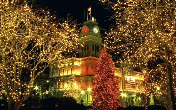 Colorful Christmas lights illuminate a historic building and trees, creating a festive holiday scene captured in HD for a vibrant PC desktop wallpaper.
