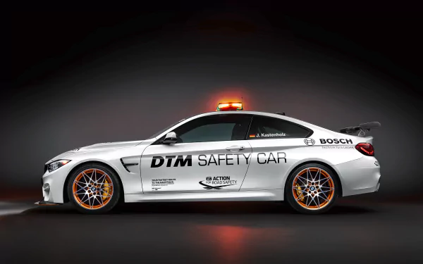 4K Ultra HD desktop wallpaper featuring a sleek white BMW M4 race car styled as a DTM safety car with branding and bright orange wheels against a dark background.