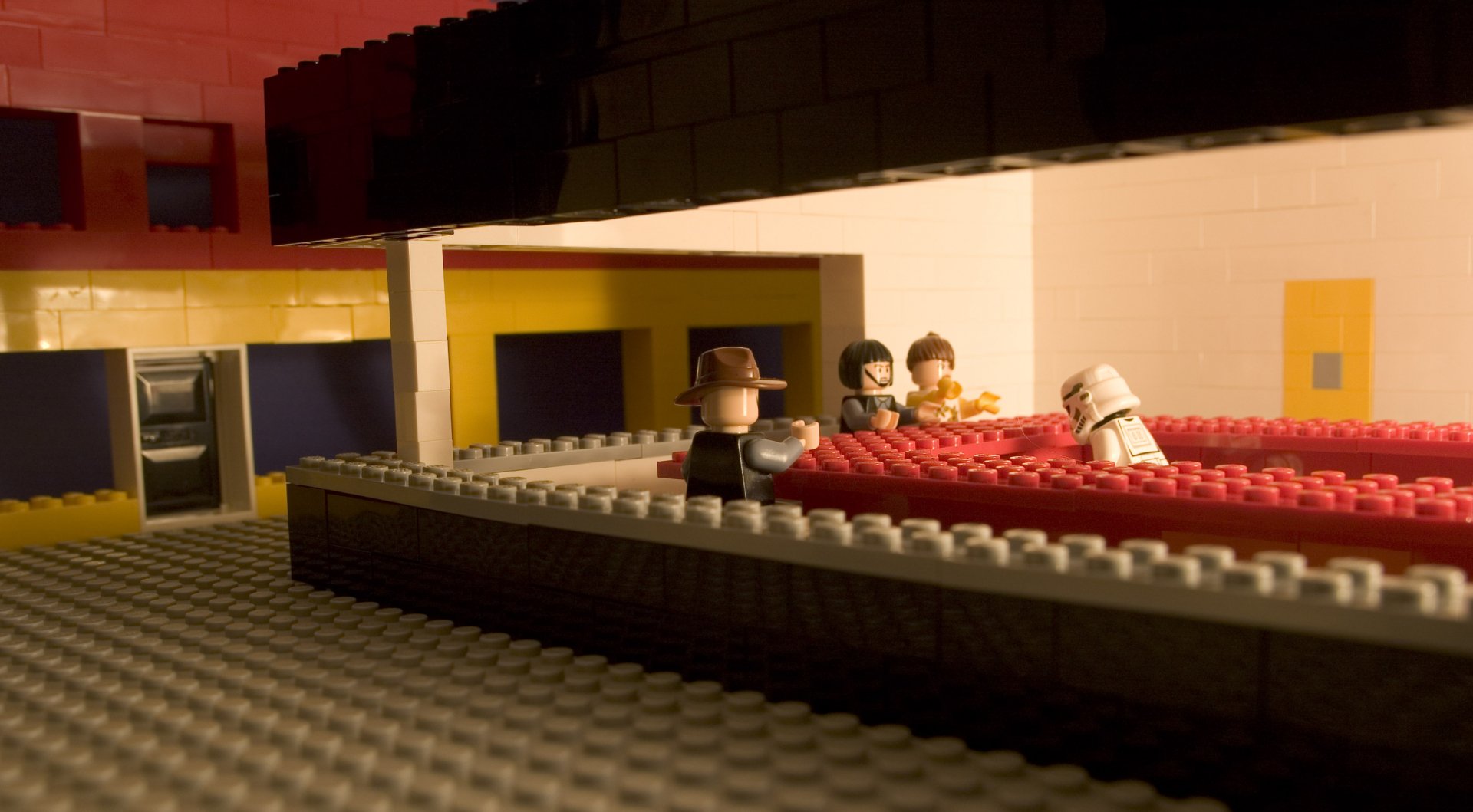 HD desktop wallpaper featuring a LEGO scene with a stormtrooper and other figures, set in an indoor man-made environment with distinct yellow and red colors.