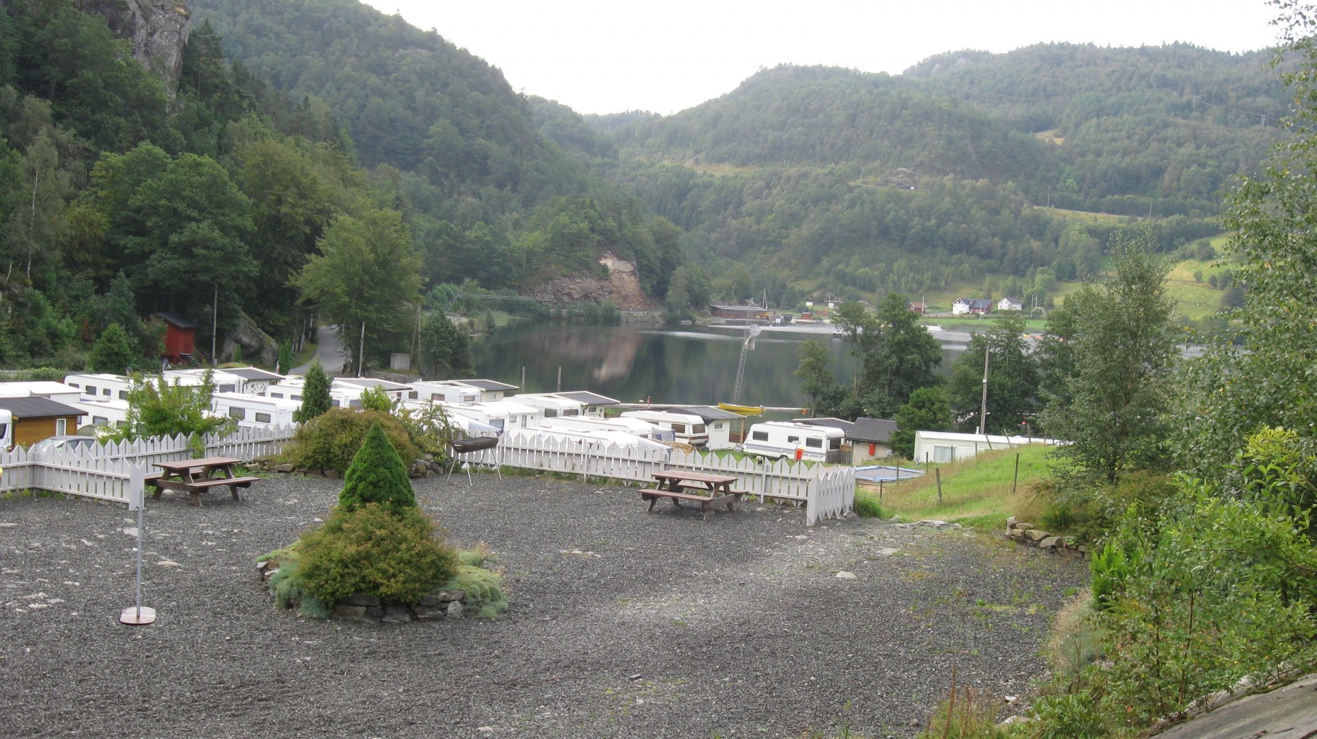 HD photography of a tranquil lakeside area with parked RVs, picnic tables, and surrounding forested hills, captured as a PC desktop wallpaper background.