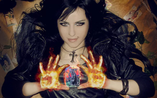 Gothic woman with burning hands holds a glowing tarot card beneath a cross pendant, dark mystical mood — HD PC desktop wallpaper/background.