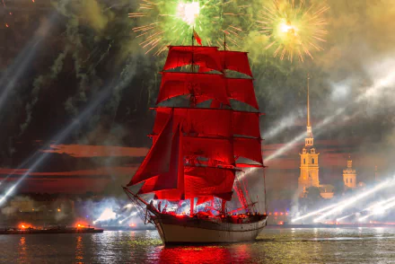 A tall ship with vibrant red sails glides on the river in Saint Petersburg, Russia, illuminated by colorful fireworks against a night sky.