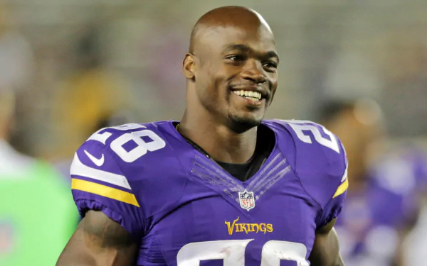 HD desktop wallpaper featuring a smiling football player in a purple Vikings jersey, number 28, on the field.