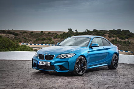 5K Ultra HD PC desktop wallpaper featuring a blue BMW M2 sports car (vehicle) parked on cobblestone, showcasing BMW styling and an aggressive stance.