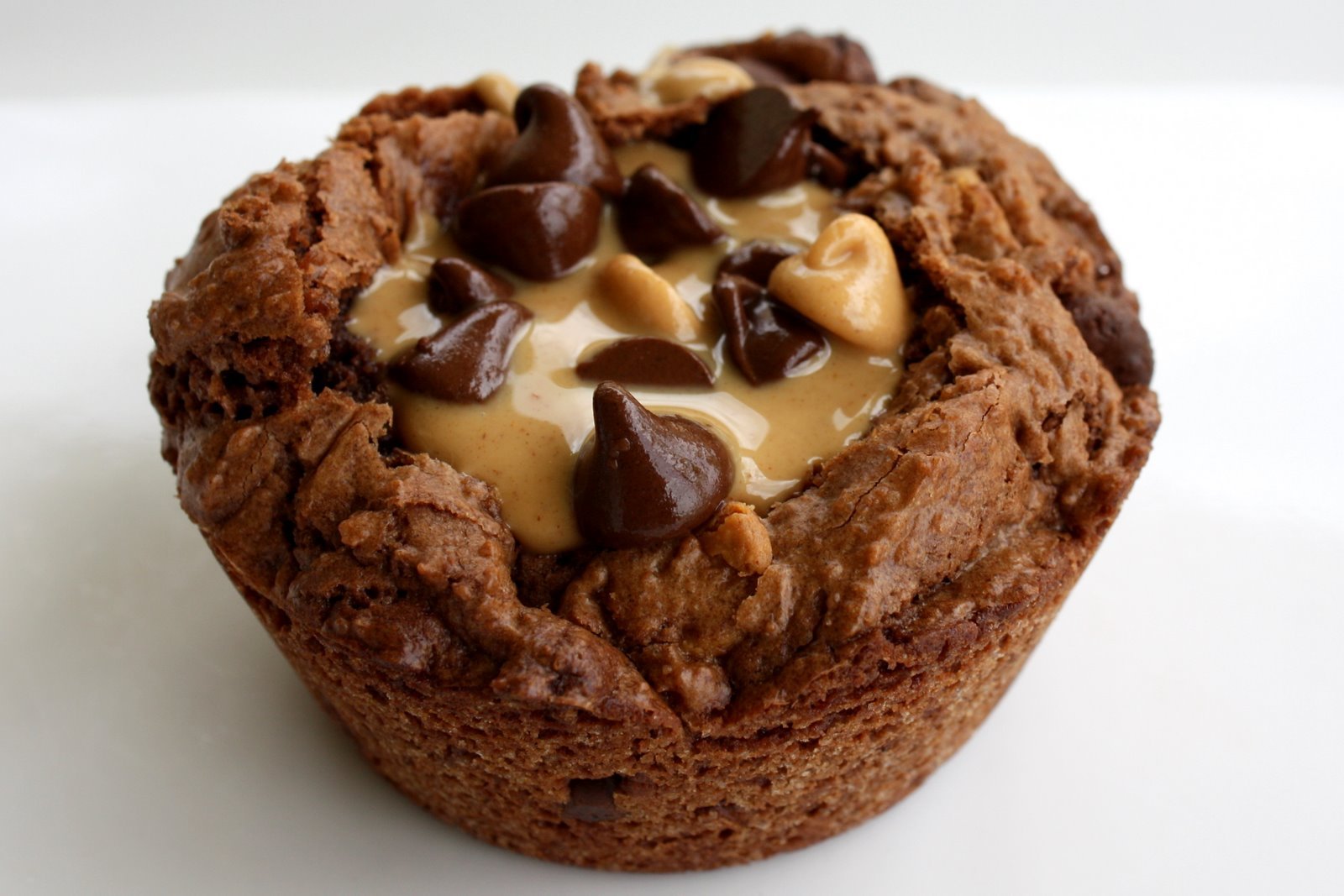 HD PC desktop wallpaper featuring a close-up of a rich chocolate muffin topped with chocolate chips and peanut butter, highlighting sweets and food in vivid detail.