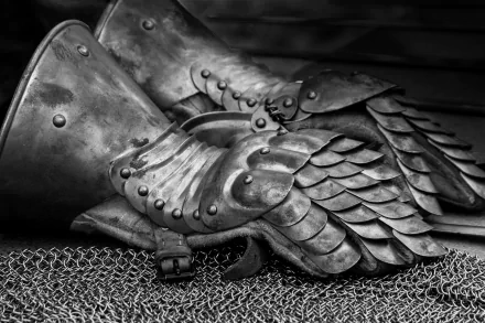 Black-and-white 2K Quad HD PC desktop wallpaper: medieval man-made armor — layered plate gauntlets resting on chainmail.