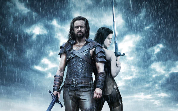 HD PC desktop wallpaper featuring characters from the movie Underworld: Rise of the Lycans, standing ready in armor under a stormy, rain-filled sky.