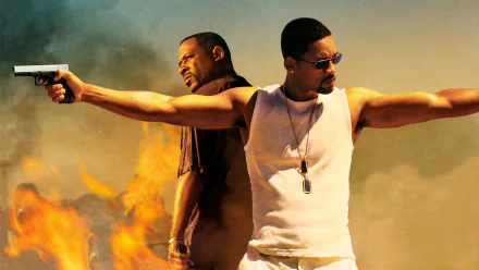 HD PC desktop wallpaper of Bad Boys II: two men back-to-back, arms outstretched holding pistols, wearing dog tags and sunglasses, flames and a smoky sky behind them.