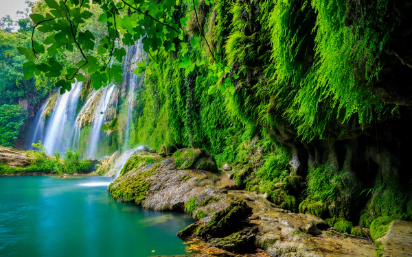 4K Ultra HD PC desktop wallpaper/background: lush green nature with a cascading waterfall over moss-covered cliffs into a turquoise pool.