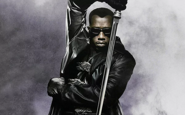 Blade II movie HD PC desktop wallpaper: leather-clad vampire hunter in sunglasses gripping a long sword against a smoky gray background.