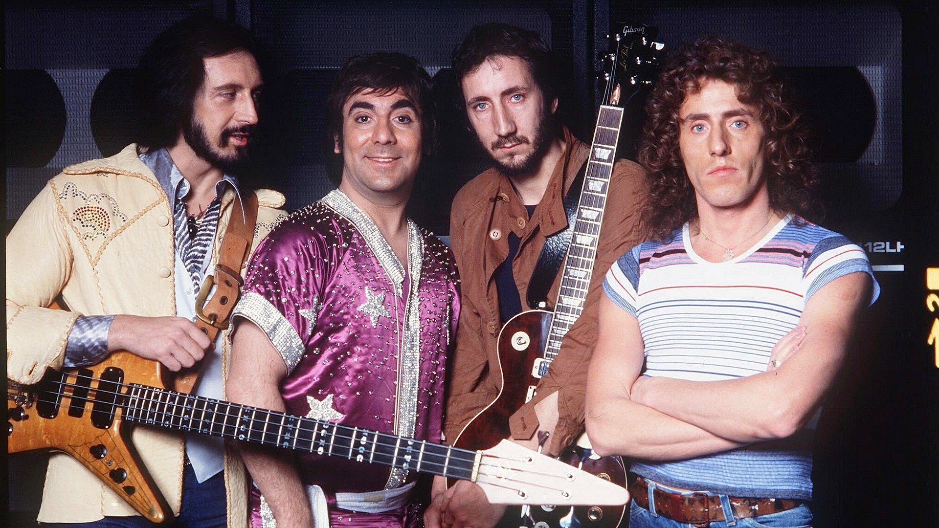 HD PC desktop wallpaper featuring the iconic rock band The Who with members holding guitars, set against a dark background highlighting their classic 1970s style.